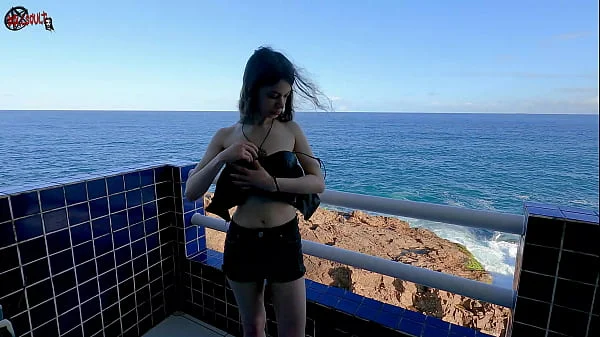 Mel strips on the balcony in front of people